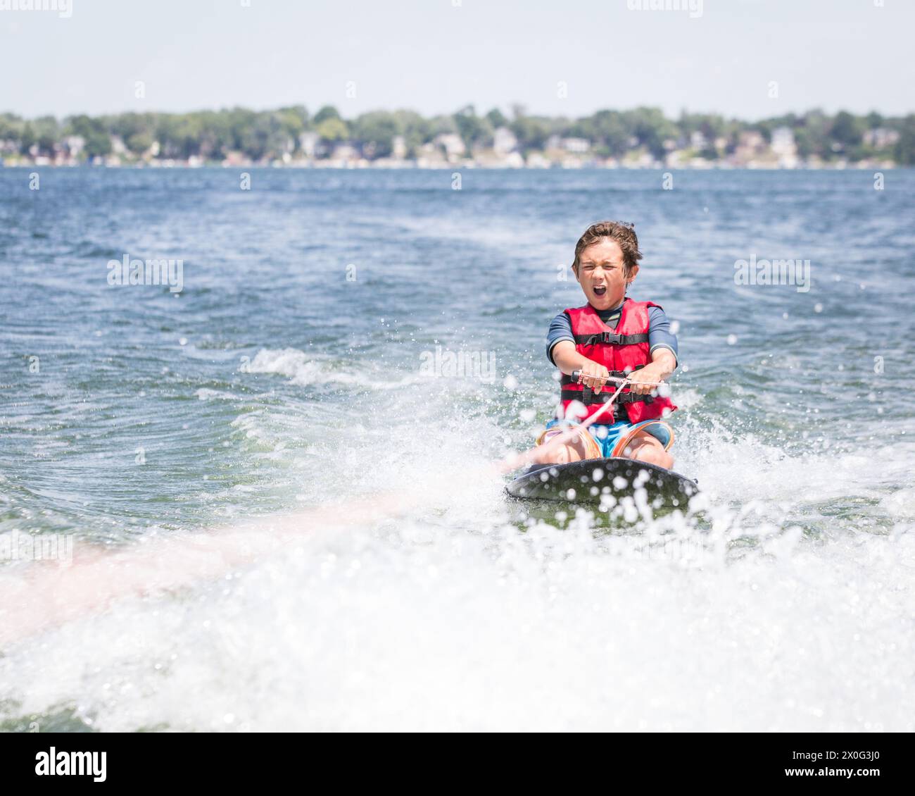 Der Junge macht es Spaß, in Syrakus zu knieboarden. Stockfoto