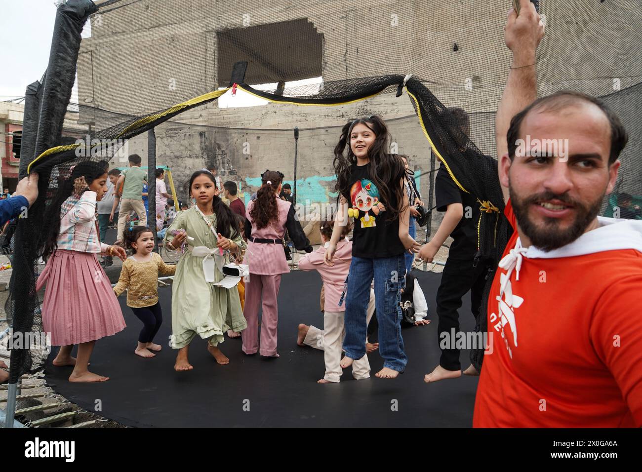 Mossul, Irak. April 2024. Irakische Kinder spielen bei einem Springspiel in einem mobilen Vergnügungspark, während sie Eid al-Fitr feiern, der das Ende des muslimischen Fastenmonats Ramadan in der Altstadt von Mosul im Nordirak markiert (Foto: Ismael Adnan/SOPA Images/SIPA USA) Credit: SIPA USA/Alamy Live News Stockfoto