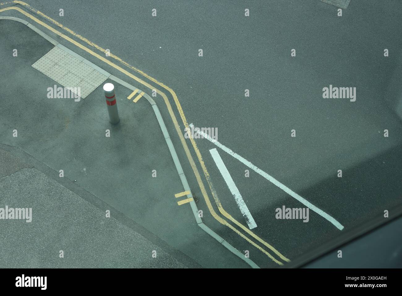 Straßenmarkierungen und Straßenbelag mit Bordsteinkanten, weißen und gelben Linien Stockfoto