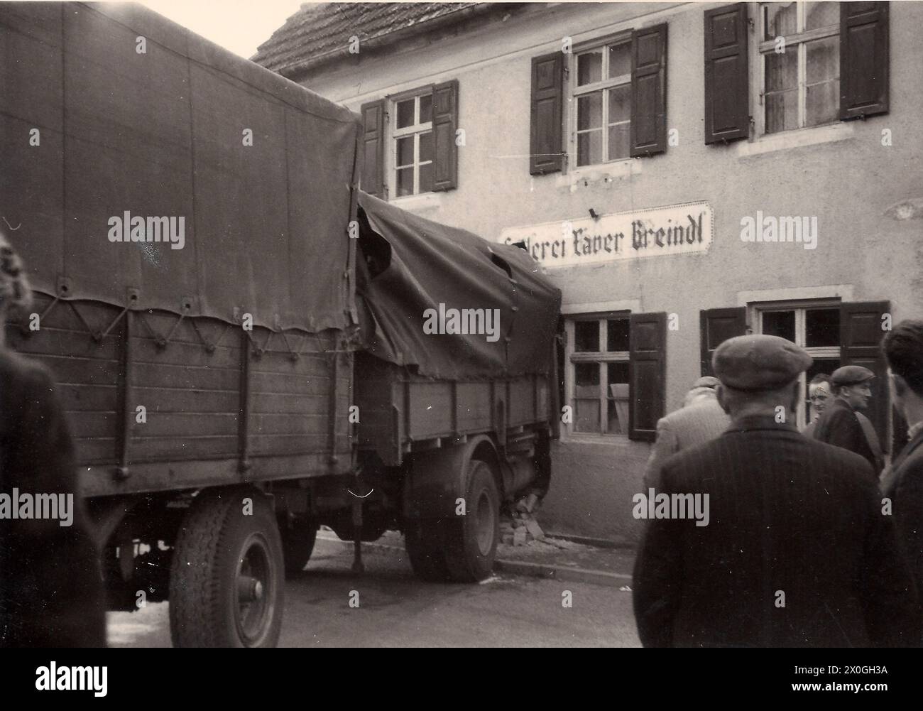 Ein LKW mit Anhänger, der in die Wand einer Sattlerei gebracht wird. Foto, das 1962 an einem unbekannten Ort aufgenommen wurde. [Automatisierte Übersetzung] Stockfoto