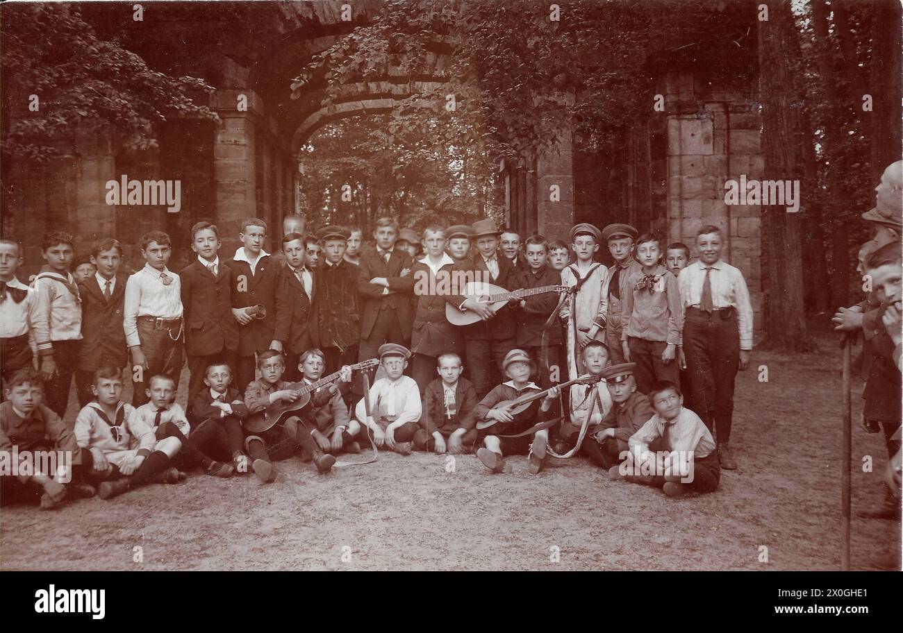 Eine große Gruppe von Jungen gleichen Alters, etwa 13 Jahre alt, hat sich mit ihren Instrumenten für ein Gruppenbild in einer Eiermage versammelt. Andere Kinder schauen neugierig auf den Fotografen [automatisierte Übersetzung] Stockfoto