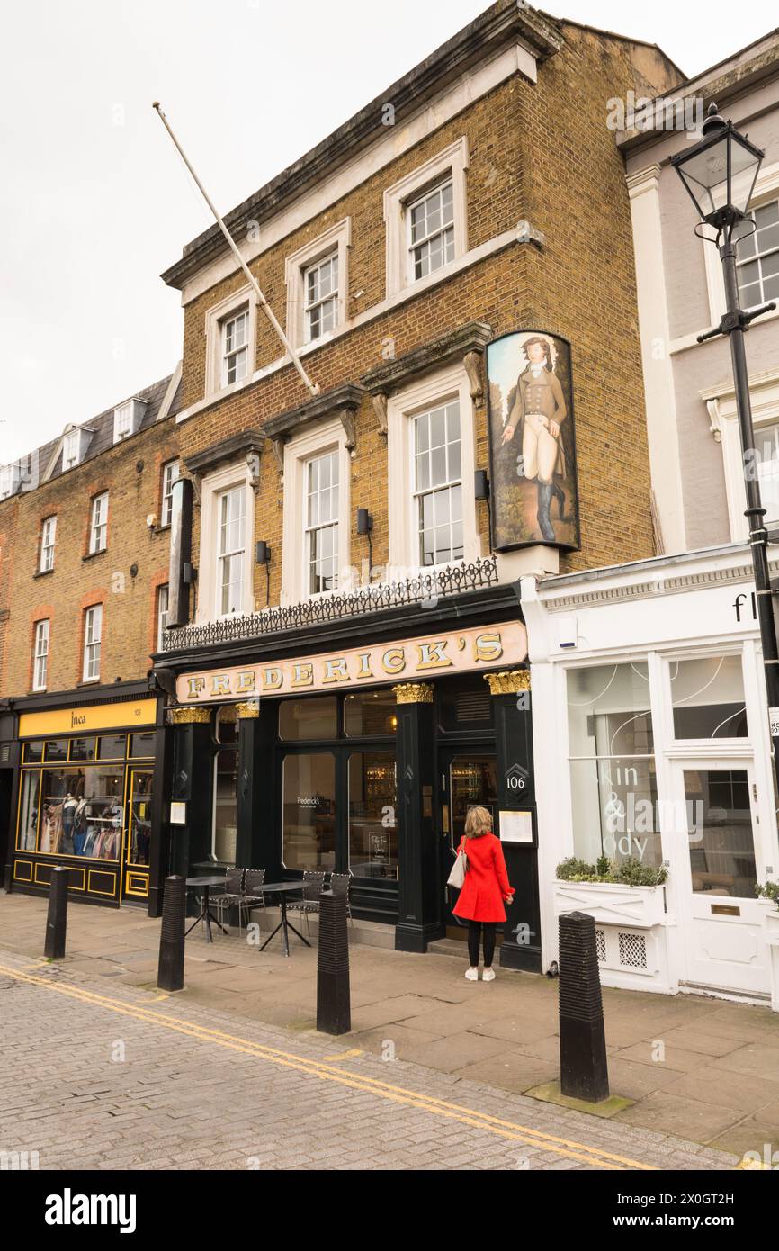 Eine Frau in Rot, die das Menü vor Frederick's Restaurant studiert, Camden Passage, Islington High Street, London, N1, England, Großbritannien Stockfoto