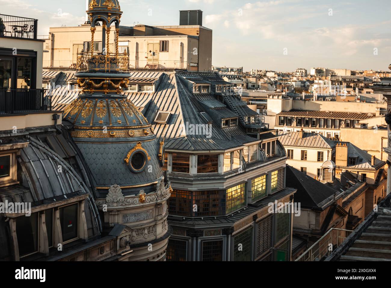 Dachblick auf das Wohngebäude von Printemps Haussmann in Paris, Frankreich. Goldene Stunde. Romantischer Sonnenuntergang mit wunderschöner Architektur. Stockfoto