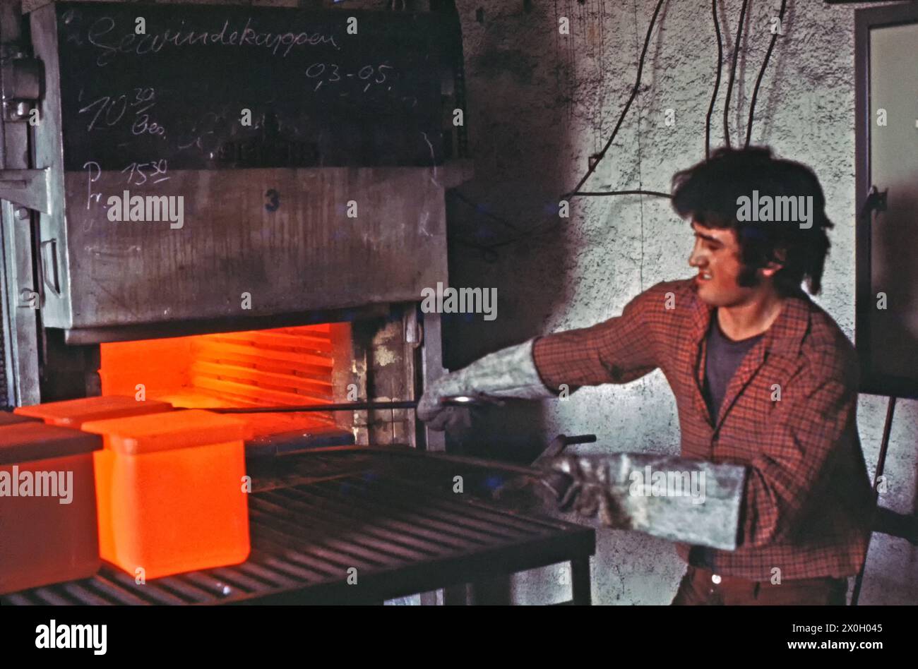 Ein junger Mann in der Lohnhärtewerkstatt, der Stahl- und Aluminiumteile härtet. [Automatisierte Übersetzung] Stockfoto