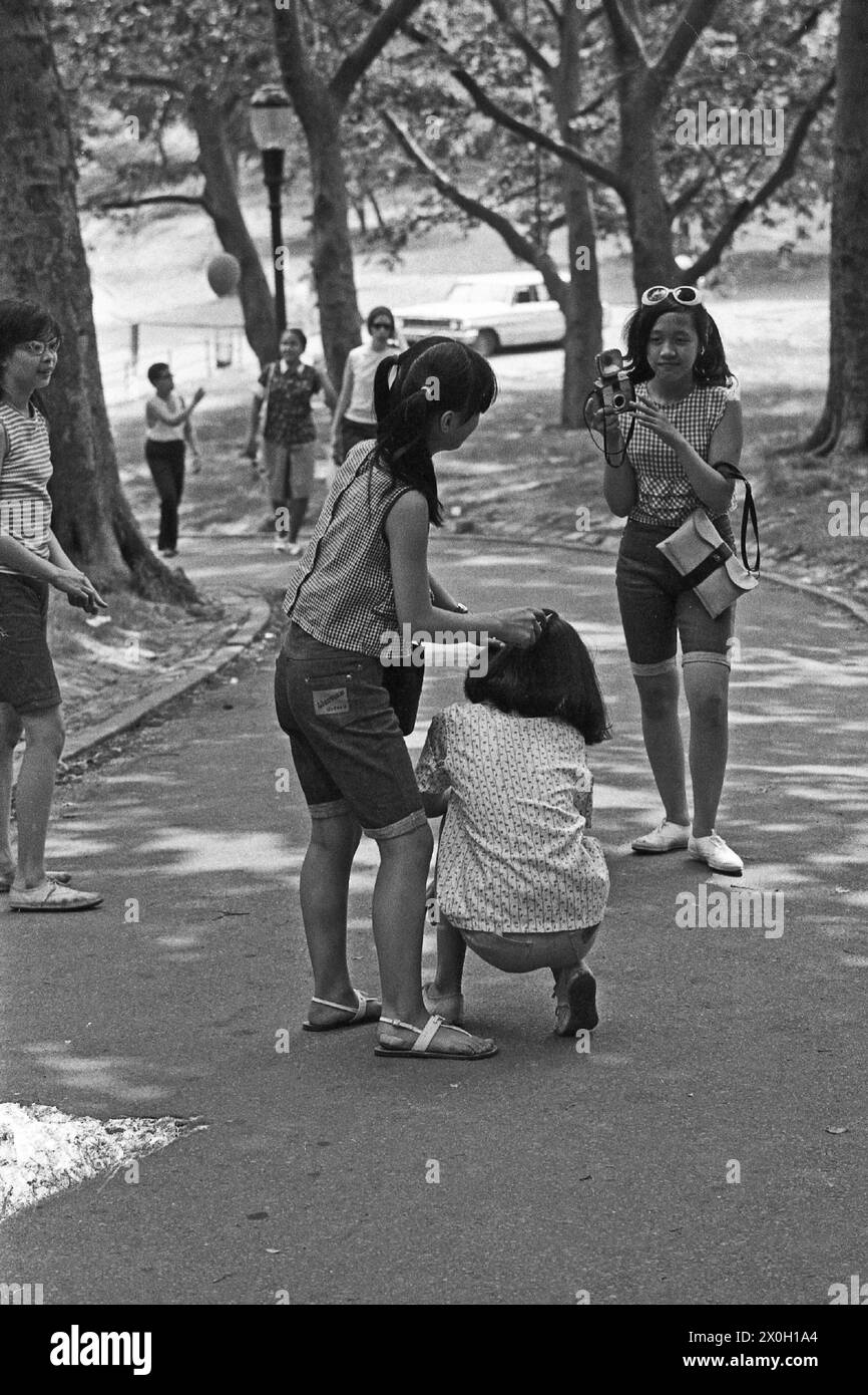 Vier junge Mädchen auf einem Gehweg im New Yorker Central Park Fotos der jeweils anderen. Stockfoto