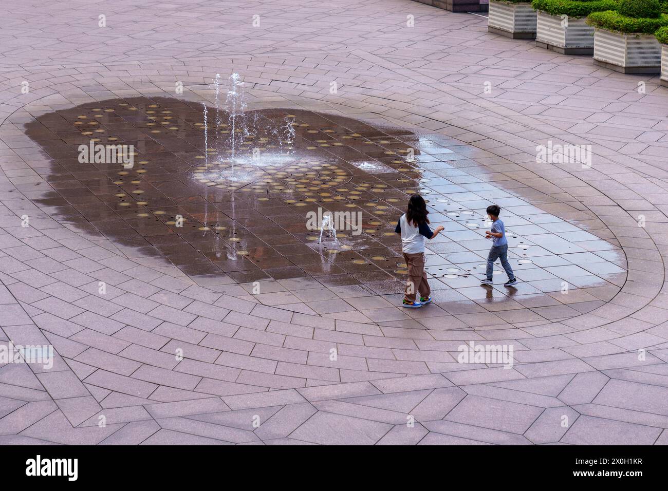 Kinder spielen auf einem Brunnen in der Stadt Stockfoto