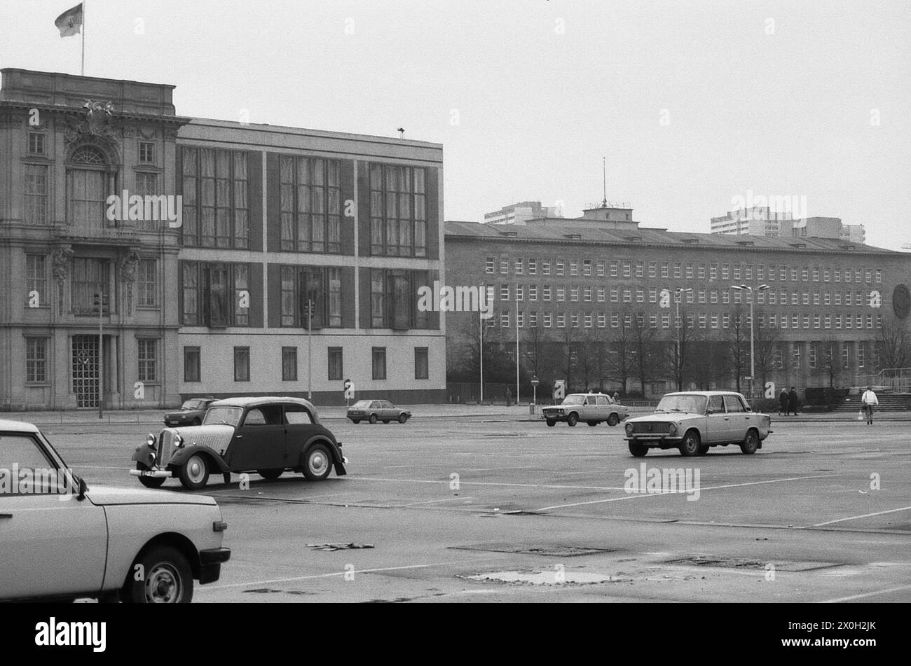 Links auf dem Bild das Staatsratsgebäude in Ost-Berlin mit DDR-Flagge auf dem Dach. Ganz im Bild das Gebäude des ZK der Sozialistischen Einheitspartei Deutschlands (SED). Im Vordergrund ein Parkplatz mit Autos. Stockfoto