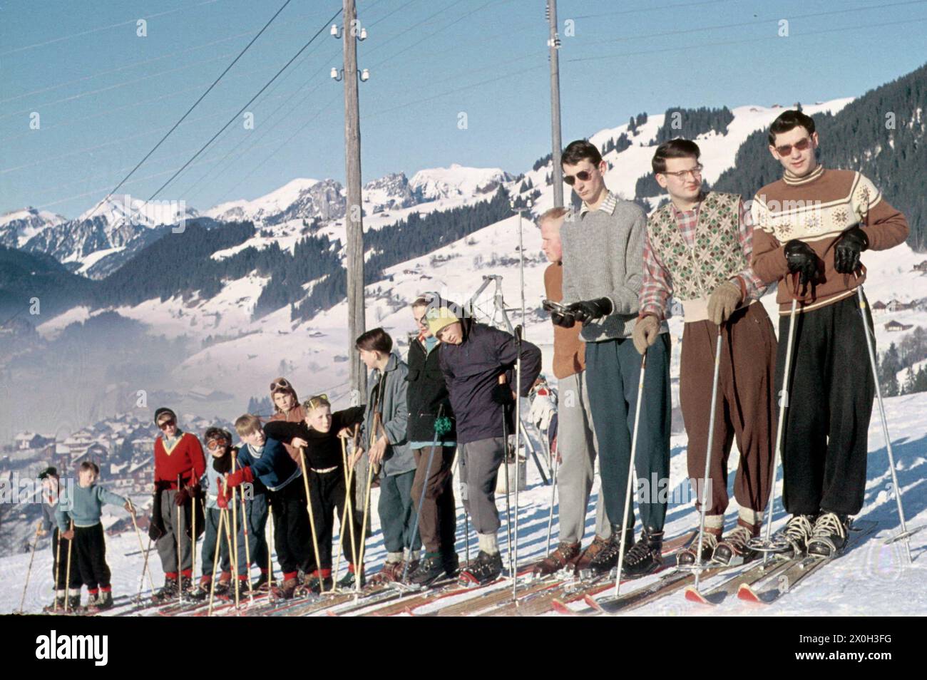 Ein Skikurs in Tirol, Leute warten hintereinander auf einem Hügel. Stockfoto