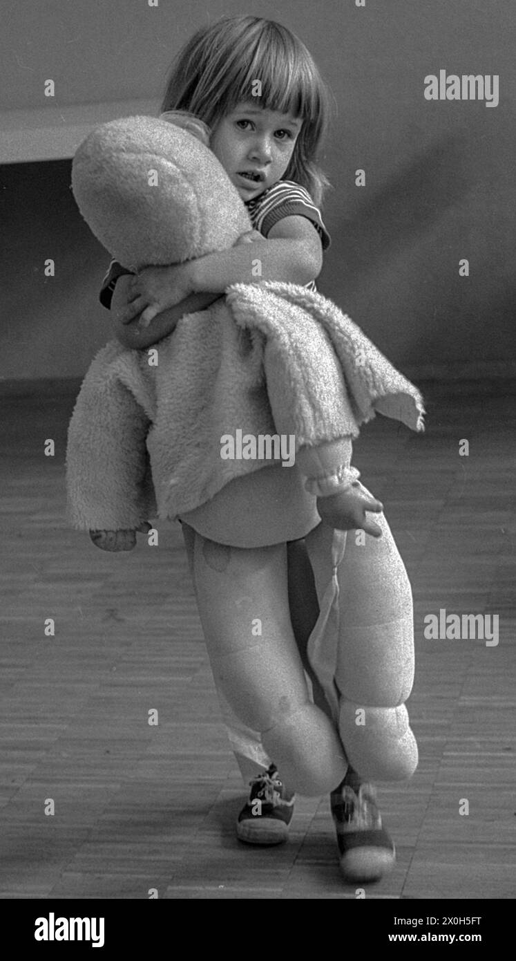 Das Mädchen hält sich liebevoll und fest an ihre lebensgroße Puppe [automatisierte Übersetzung] Stockfoto