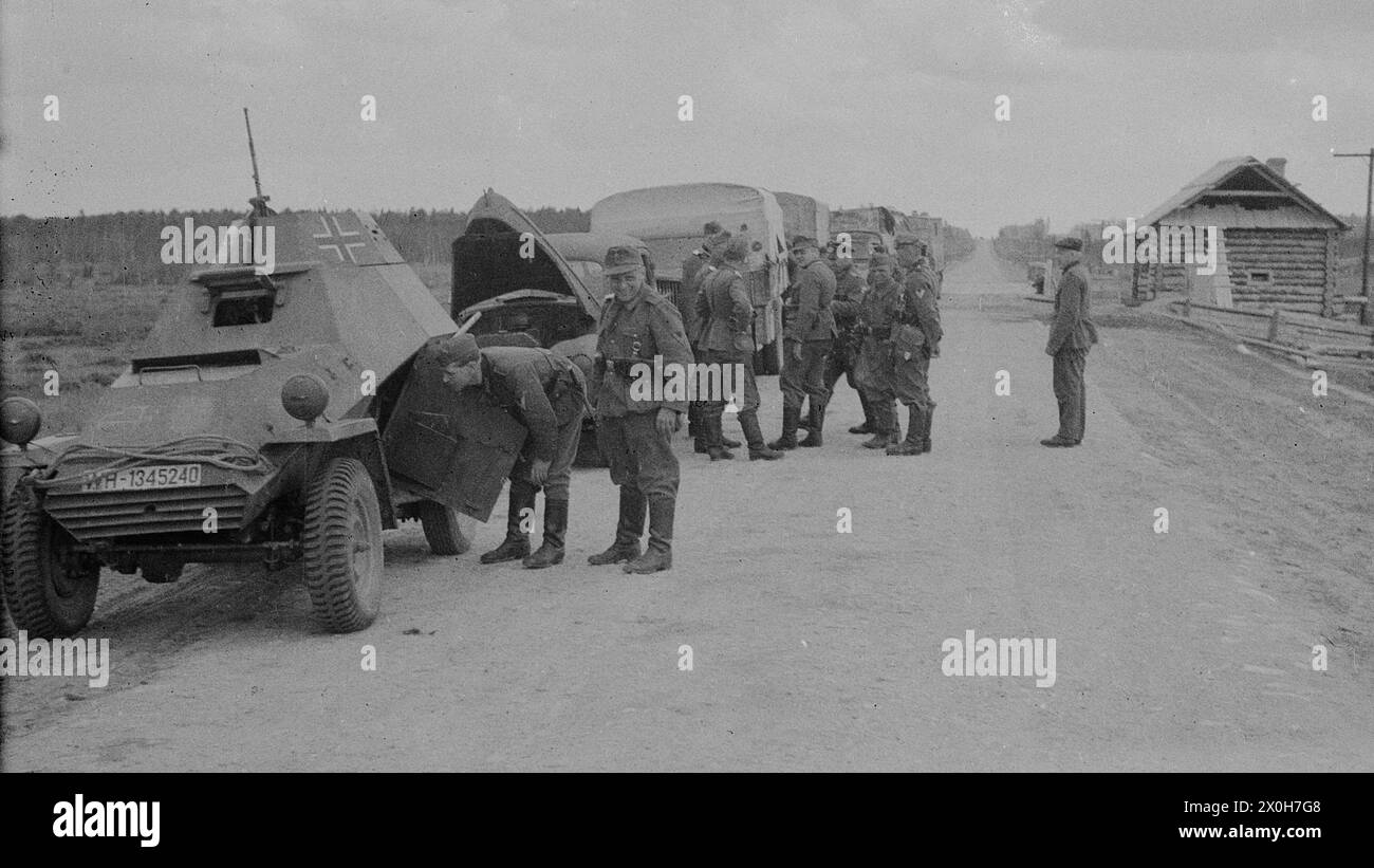 Ein Wehrmachtssoldat schaut in das Innere eines leicht gepanzerten Radfahrzeugs, das eine Säule führt. Das Bild wurde von einem Mitglied des Radfahrgrenadierregiments 2/Radfahrsicherungsregiment 2 an der Ostfront aufgenommen. Vermutlich während des Vormarsches im Sommer 1941 [automatisierte Übersetzung] Stockfoto