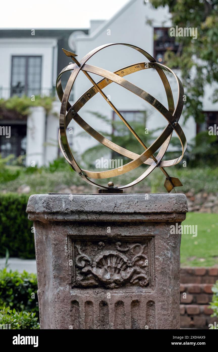 Große armillarische Sonnenuhr aus Messing oder Bronze mit erhöhten römischen Ziffern und Pfeil auf Sockel, Steinsockel mit Muster. Hotel BA Stockfoto