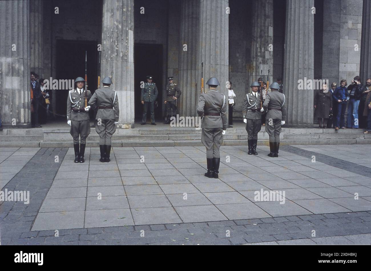 Der Wachwechsel an der neuen Wache in Berlin zieht viele internationale Besucher an. Die Wachen folgen einer strengen Zeremonie, tragen Uniformen mit Helmen und halten ihre Gewehre. Undatiertes Foto, ca. 1980. [Automatisierte Übersetzung] Stockfoto