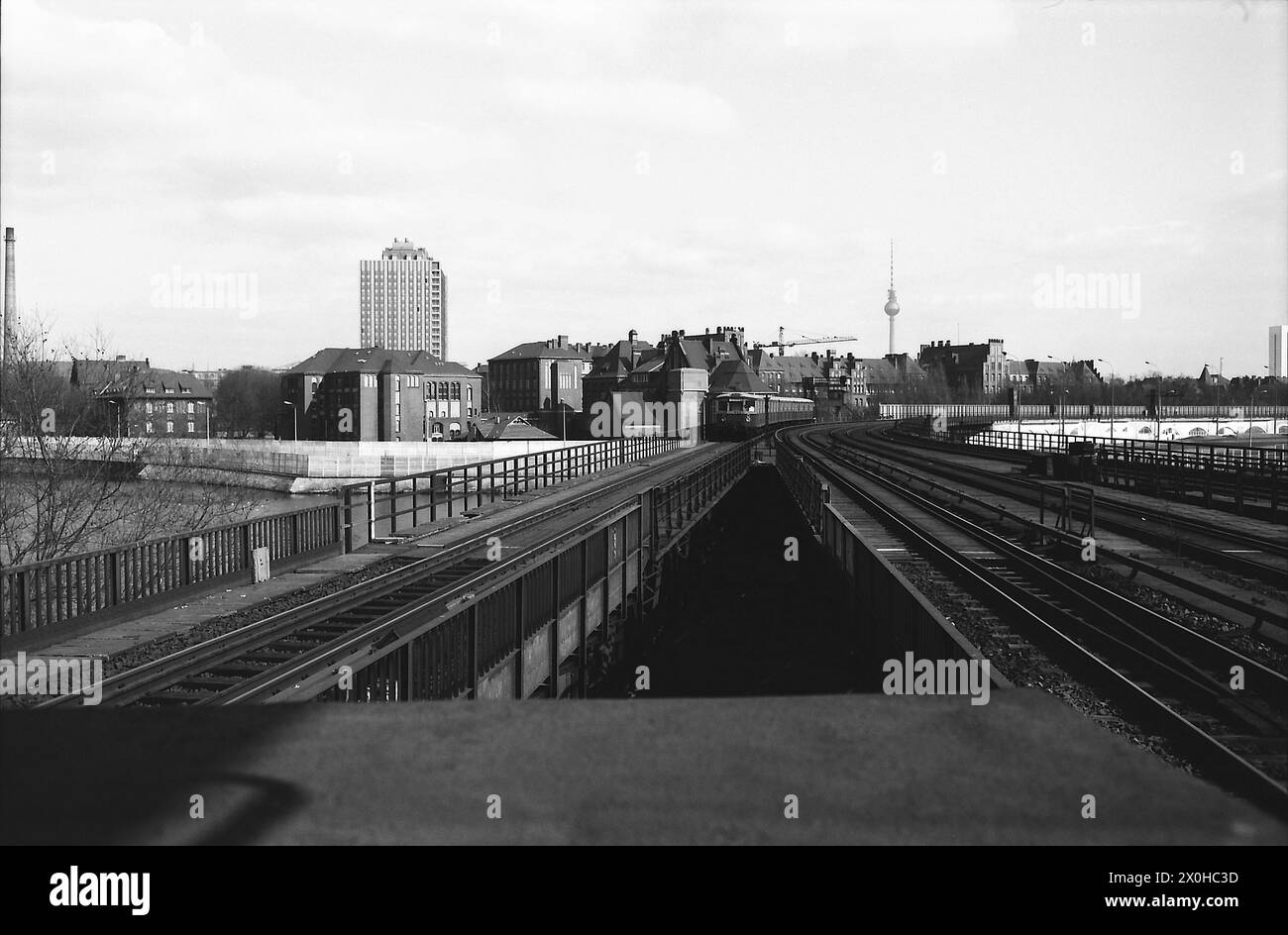 Das Bild zeigt einen einfahrenden S-Bahn-Zug in Richtung Lehrter Stadtbahnhof. Auf der anderen Seite des Kanals sind die Grenzanlagen auf der anderen Seite des Kanals deutlich sichtbar, mit der gesamten Skyline des CharitÃ. Stockfoto