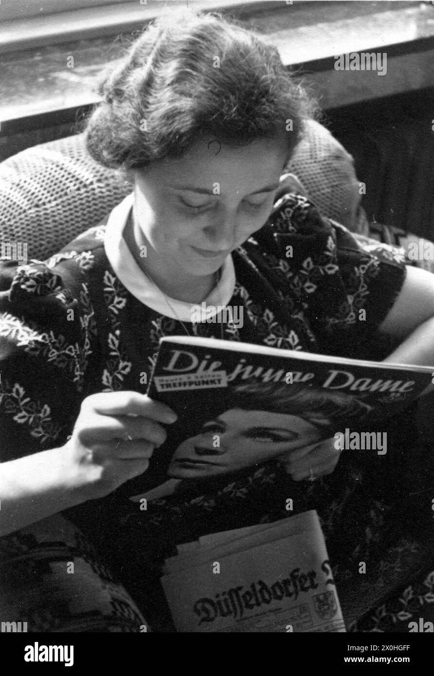Eine junge Dame liest das "die junge Dame". Stockfoto