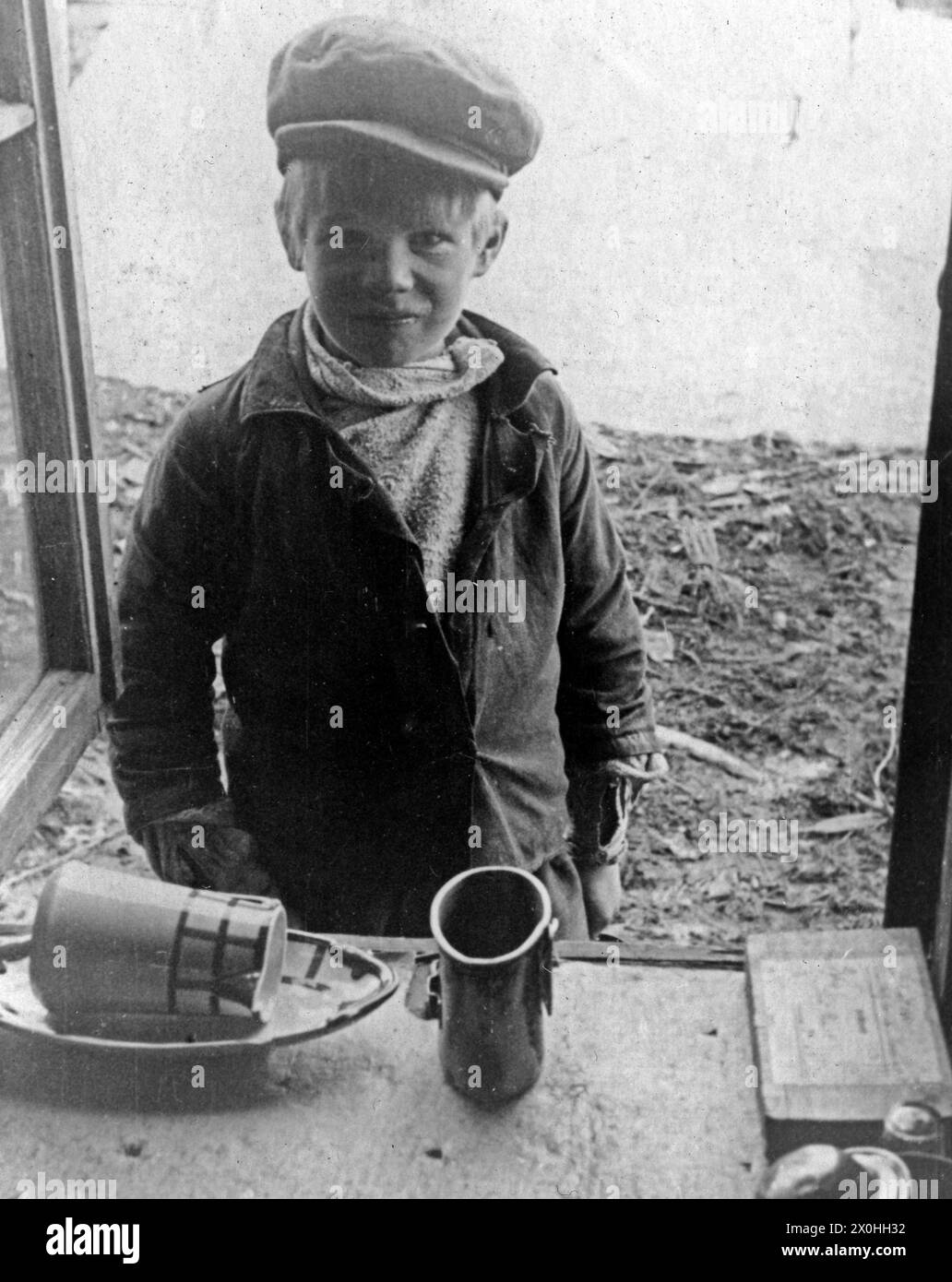 Ein kleiner Junge bittet deutsche Soldaten um Nahrung im Zweiten Weltkrieg. Stockfoto