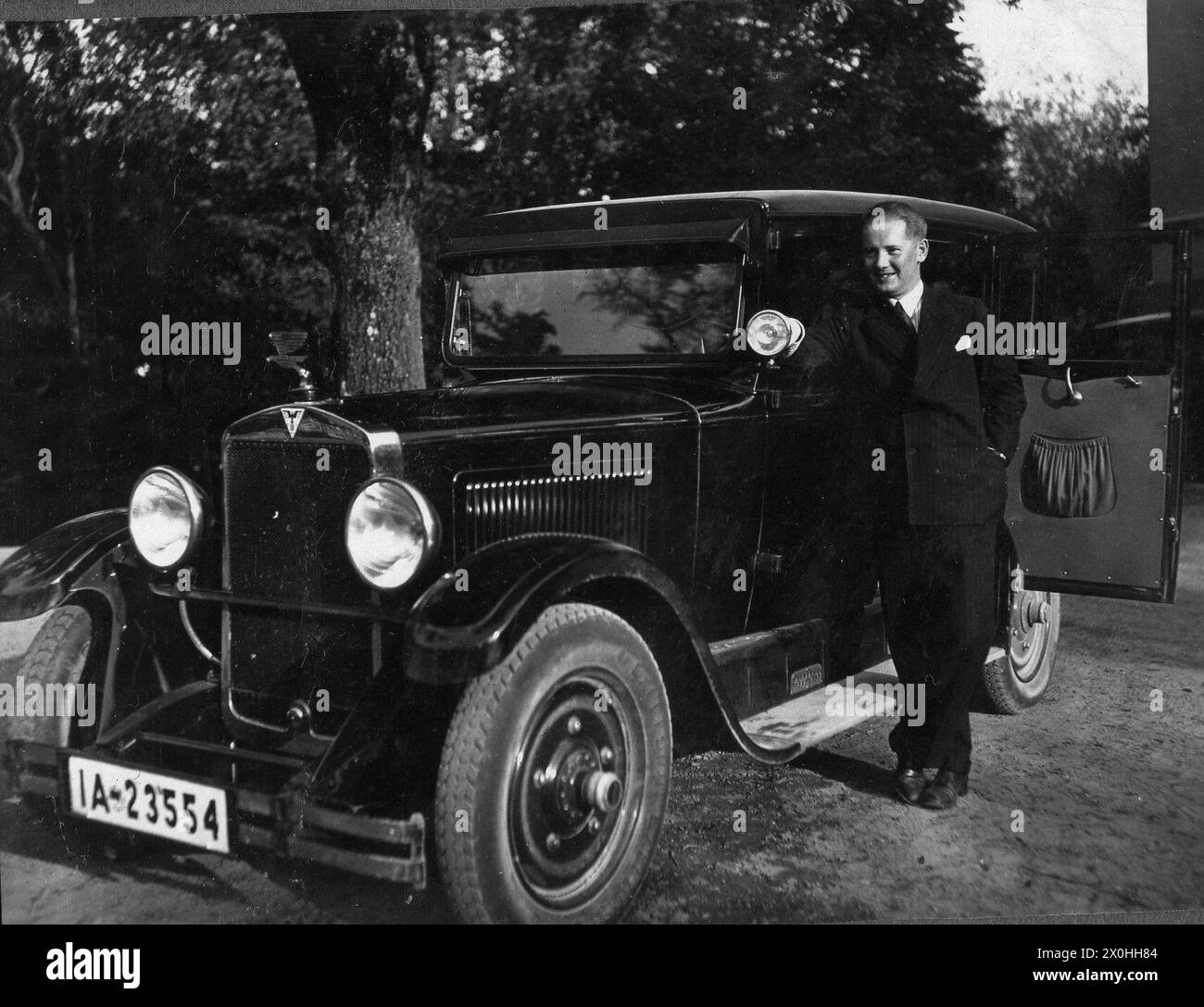 Mann stolz vor seinem Adler PKW (Aufnahmedatum: 01.01.1930-31.12.1930) Stockfoto