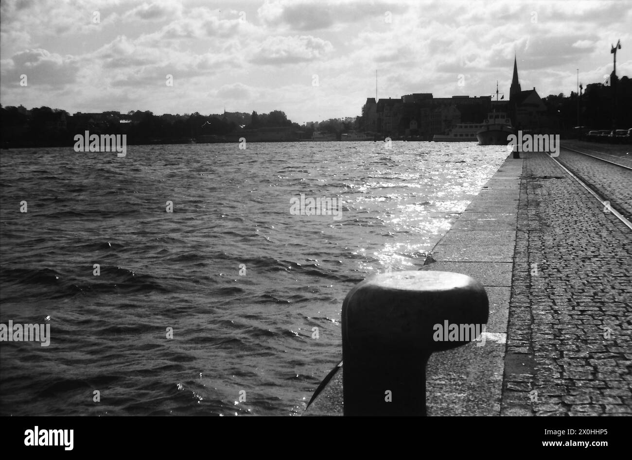 Es ist lange her, als ich die Ostseeküste in Flensburg bereiste. Ich glaube, ich habe hier ein Flensburger Hafenbecken fotografiert, denn die Kirche im Hintergrund könnte die Nikolaikirche sein. [Automatisierte Übersetzung] Stockfoto
