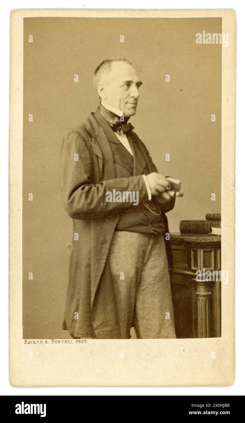 Original und klarer französischer Albumenabdruck aus den 1860er Jahren - Carte de Visite (Visiting Card oder CDV) des französischen Dramatikers und Ideologen Charles Duveyrier, der älter war, bevor er 1866 im Alter von 63 Jahren starb. Hier ist er posiert, lächelnd, ein netter, angenehm aussehender französischer Gentleman mittleren Alters, trägt einen Morgenanzug und hält ein Buch. Aus dem Studio von (Hippolyte) Bayard & Bertell, Rue de la Madeleine, Paris, Frankreich. Hippolyte Bayard war eine der ersten Experimentatoren in der Fotografie, eine Pionierfotografin, die von 1861 bis 1866 in diesem Studio aktiv war. Stockfoto