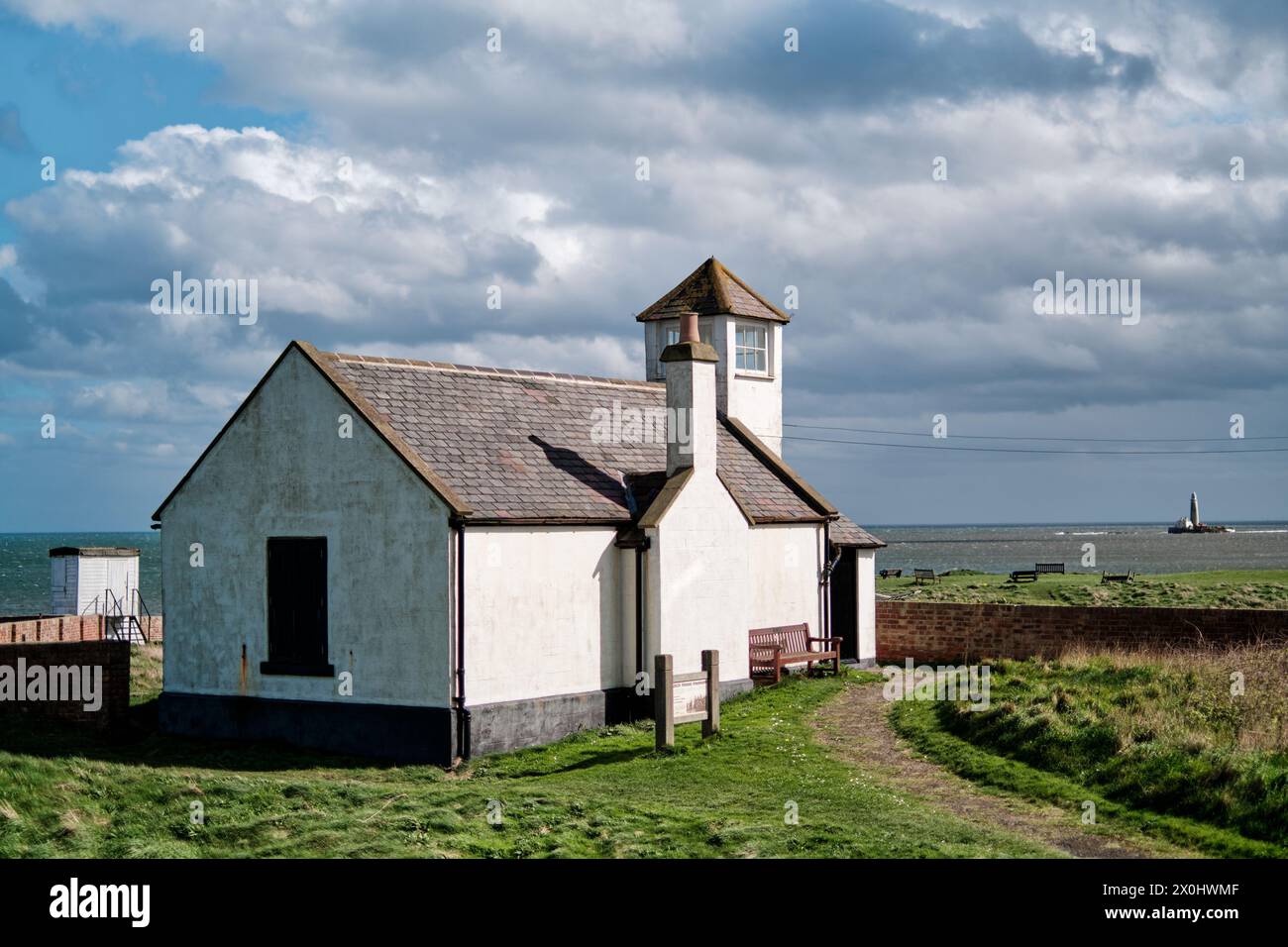 Seaton Sluice Watch House Museum , Wachturm und St Mary's Leuchtturm in der Ferne an der Northumberland Küste. Stockfoto