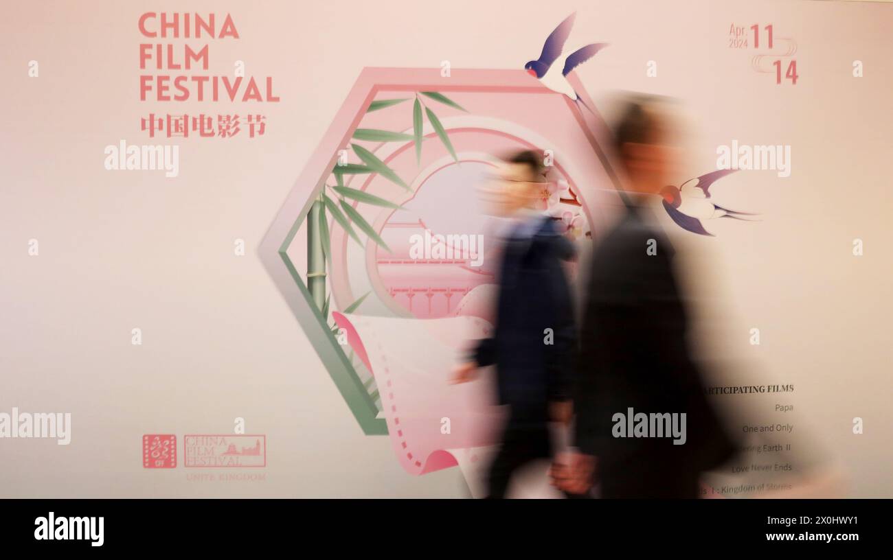 London, Großbritannien. April 2024. Mitarbeiter gehen an einem Poster des China Film Festivals 2024 in London, Großbritannien, am 11. April 2024 vorbei. Das China Film Festival 2024 startete am Donnerstagabend hier, um den chinesisch-britischen Kulturaustausch weiter zu stärken. UM MIT 'chinesisches Filmfestival Kicks off in London' zu GEHEN Credit: Li Ying/Xinhua/Alamy Live News Stockfoto