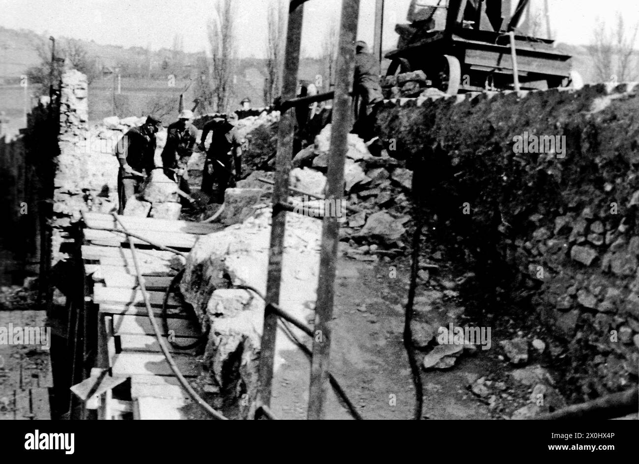 Am 1. April 1945 sprengten deutsche Einheiten Arch 6 in der Mitte der Brücke. In den folgenden Jahren überspannte eine provisorische Holzkonstruktion die Lücke im Gebäude. Der Eröffnung der Neuen Hauptbrücke 1954 folgte der Wiederaufbau der Alten Hauptbrücke, der 1957 abgeschlossen wurde. Durch den Ausbau des Mains zu einer wichtigen Schifffahrtsroute wurden die drei Mittelbögen fünf bis sieben durch einen rund 58 Meter langen Spannbetonbalken ersetzt, der den Main überspannte, der durch das Goßmannsdorfer Stauwerk gestaut wurde. [Automatisierte Übersetzung] Stockfoto