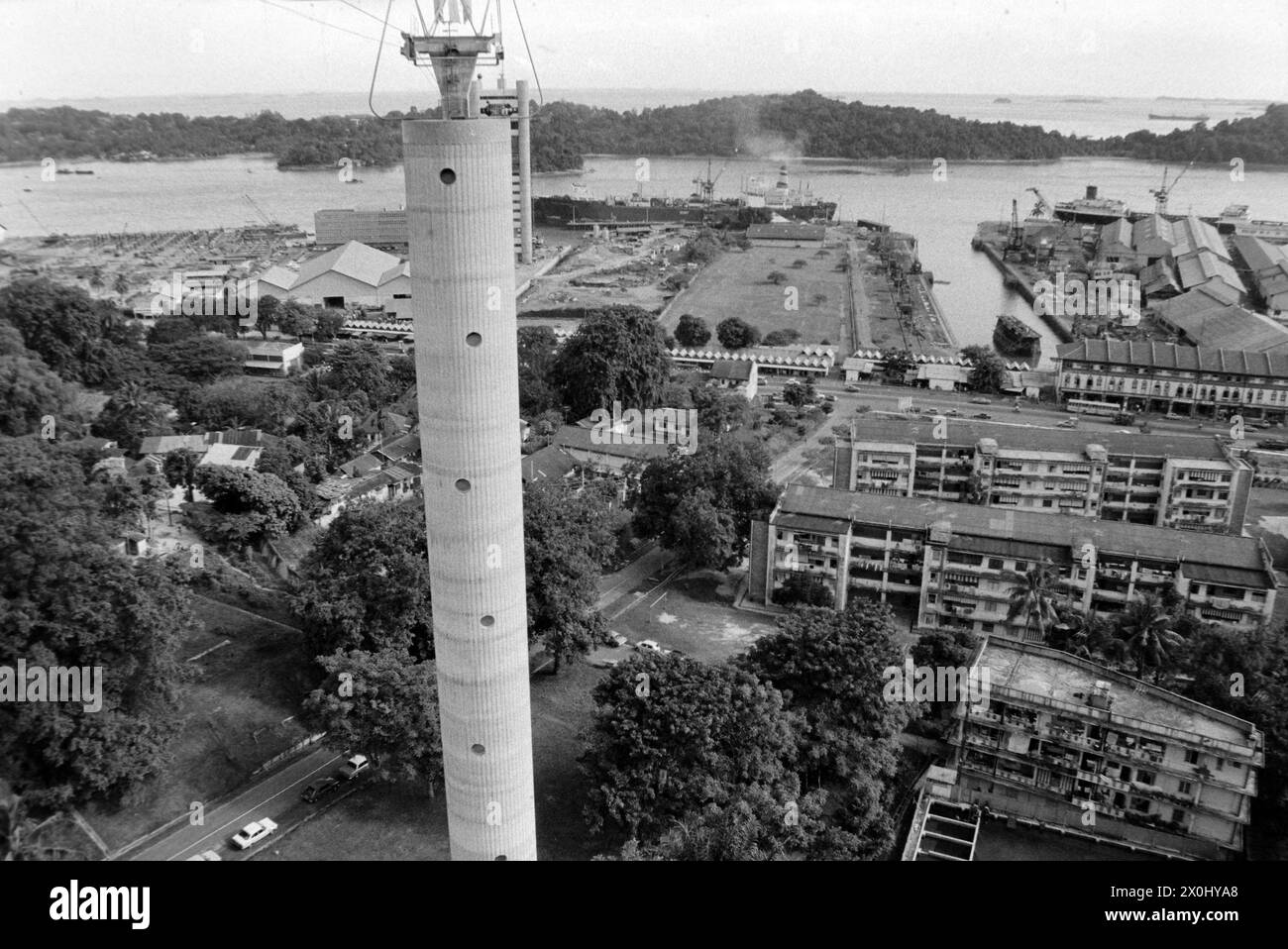 Blick auf die Insel Sentosa in Singapur und eine hohe Betonsäule der Seilbahn, die die beiden Inseln verbindet [automatisierte Übersetzung] Stockfoto