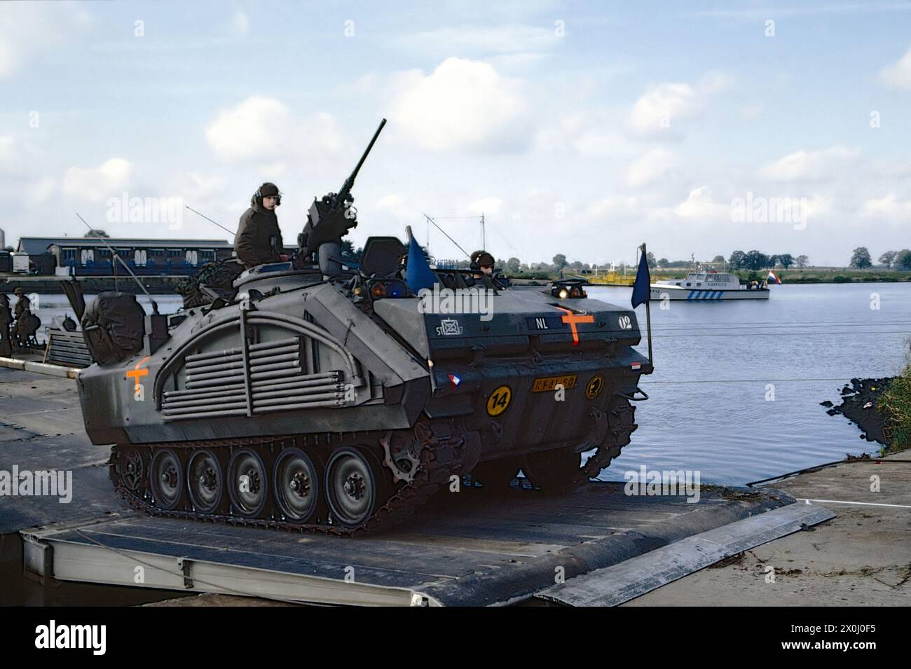 - NATO-Übungen in den Niederlanden, ein gepanzerter Besatzungsträger der niederländischen Armee YPR-765 überquert die Maas auf einer Pontonbrücke (Oktober 1983) - Esercitazioni NATO in Olanda, un veicolo corazzato da trasporto truppe YPR-765 dell'Esercito Olandese attraversa il fiume Mosa su un ponte di barche (Ottobre 1983) Stockfoto