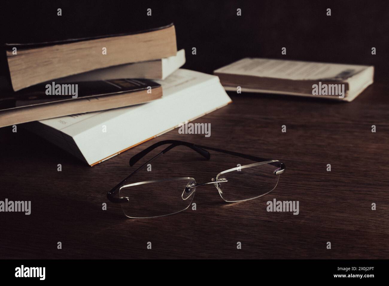 Klassische Gläser und Bücherstapel auf dem Tisch. Literaturkonzept. Brillen neben alten Büchern. Bildung und Wissen. Forschungskonzept. Club buchen Stockfoto