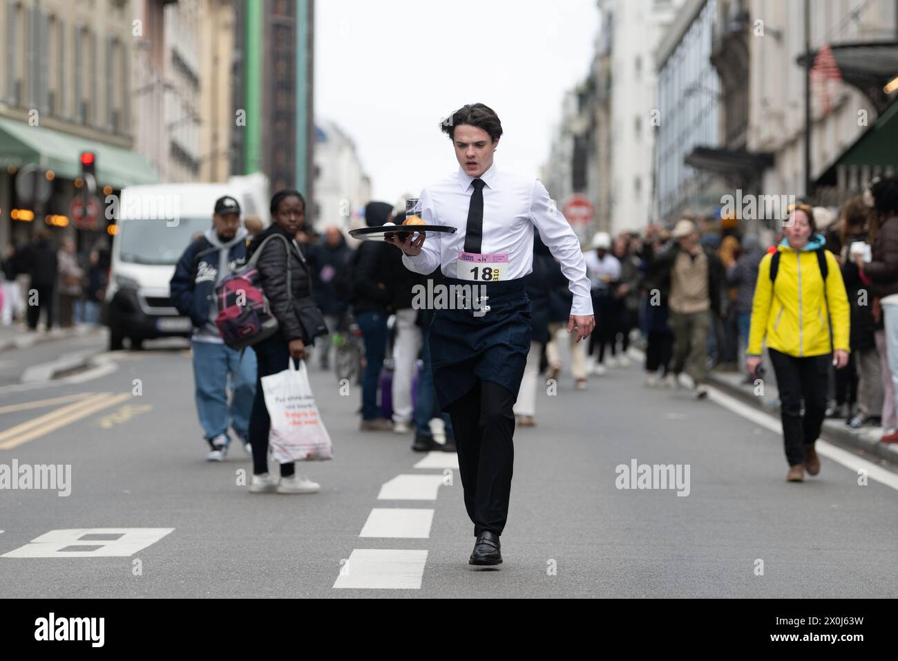 Ein Wettbewerber in La Course des Cafés rennt durch die Straßen von Paris Stockfoto