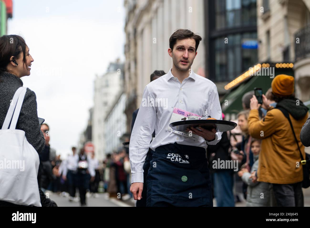 Ein Wettbewerber in La Course des Cafés rennt durch die Straßen von Paris Stockfoto