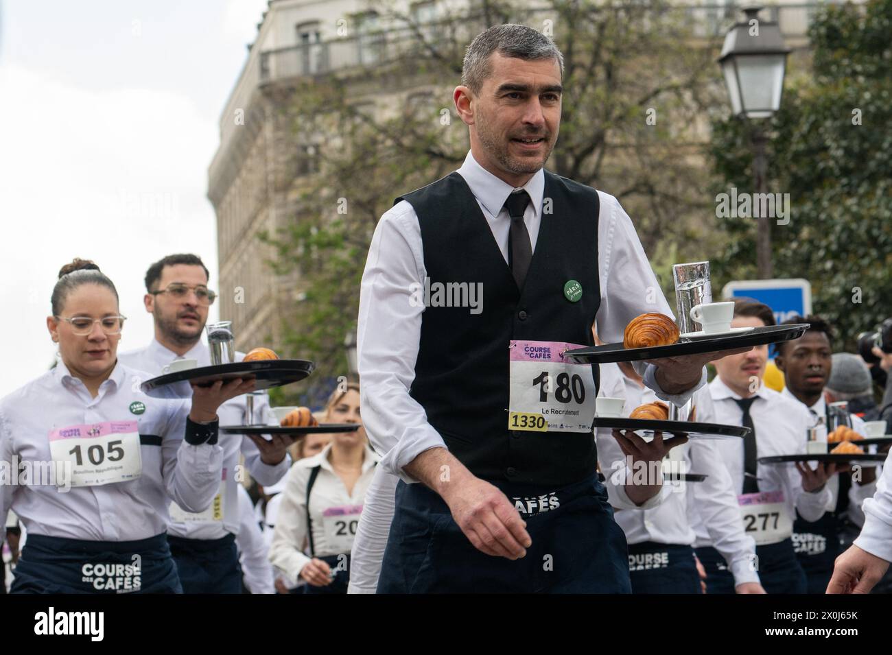 Die Teilnehmer im La Course des Cafés rennen durch die Straßen von Paris Stockfoto