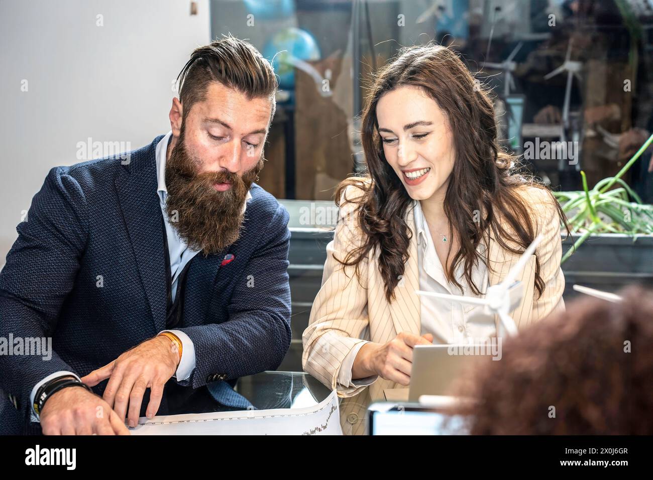 Produktive Konsultation im Gange. Ein gut gekleideter Mann und eine Frau bewerten die Arbeit an einem Laptop und zeigen ein professionelles und dynamisches Arbeitsumfeld. Foc Stockfoto