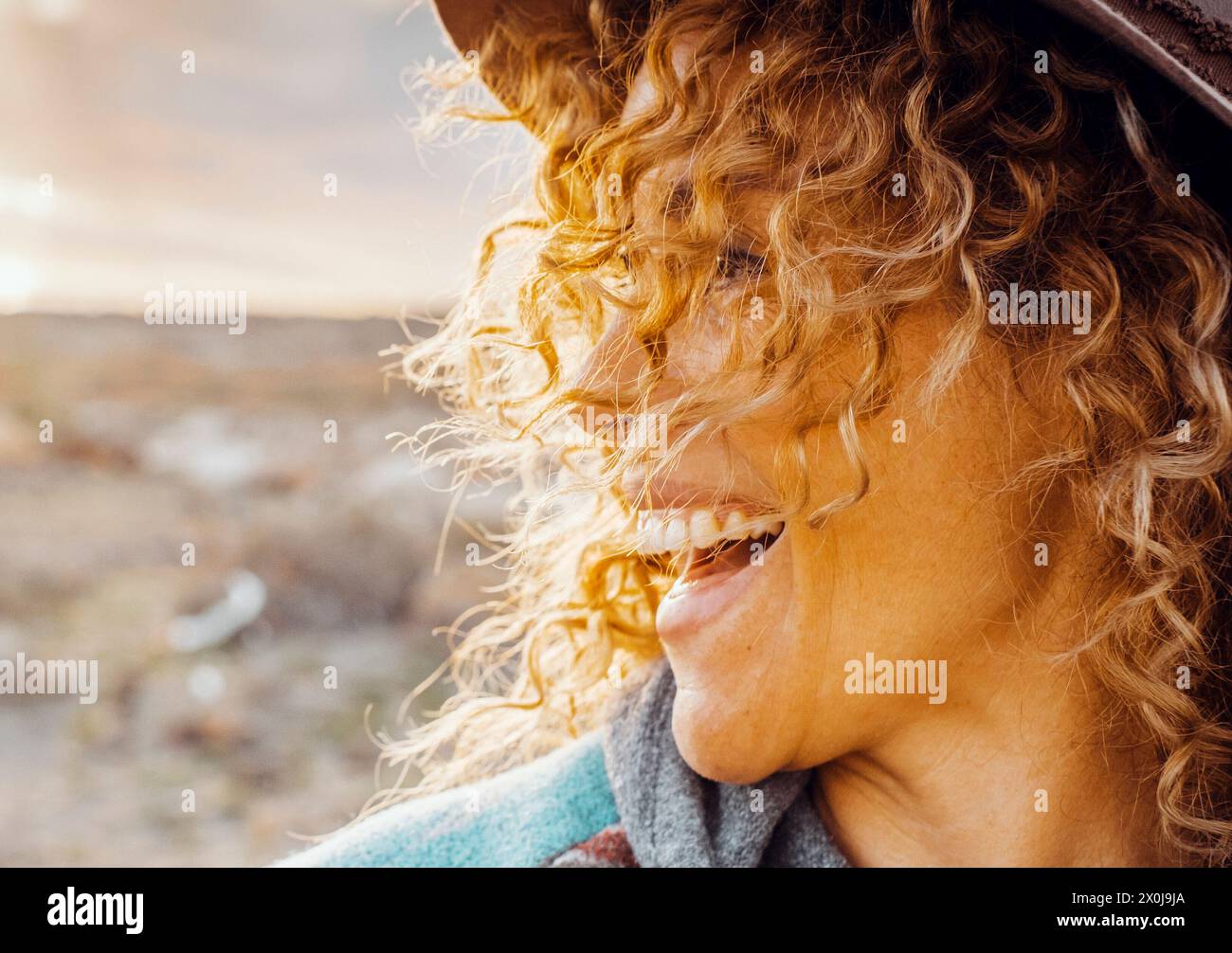 Seitenansicht Porträt einer fröhlichen jungen erwachsenen Frau, die lächelt und Fu lacht, allein bei Freizeitaktivitäten im Freien mit der Natur im Hintergrund. Reisende und Touristen. Menschen draußen genießen das Leben Stockfoto