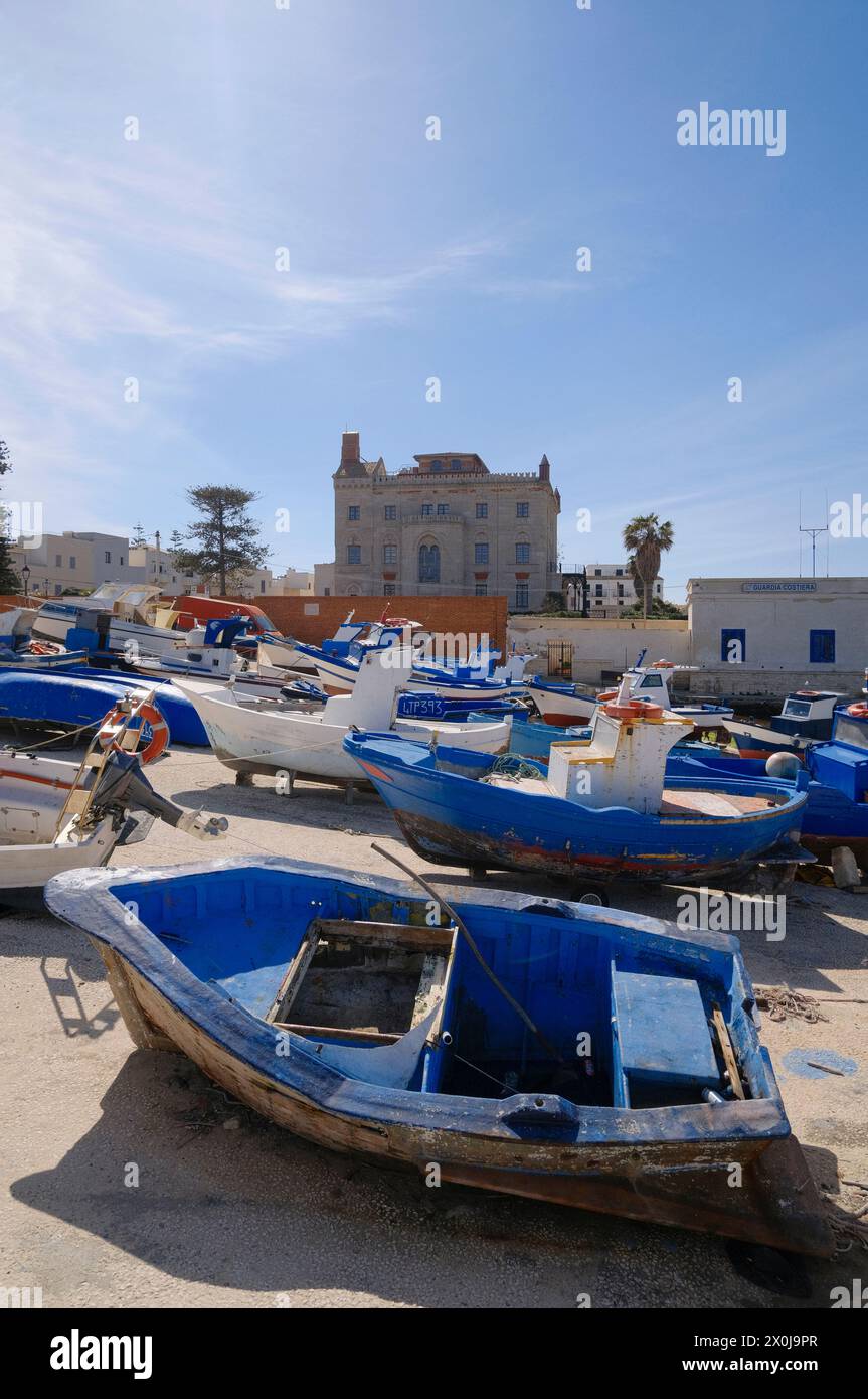 Italien, sizilien, mittelmeer, Ägadische Inseln, Insel Favignana); Boote an Land im Hafen und die Fassade des Florio Palace im Hintergrund Stockfoto