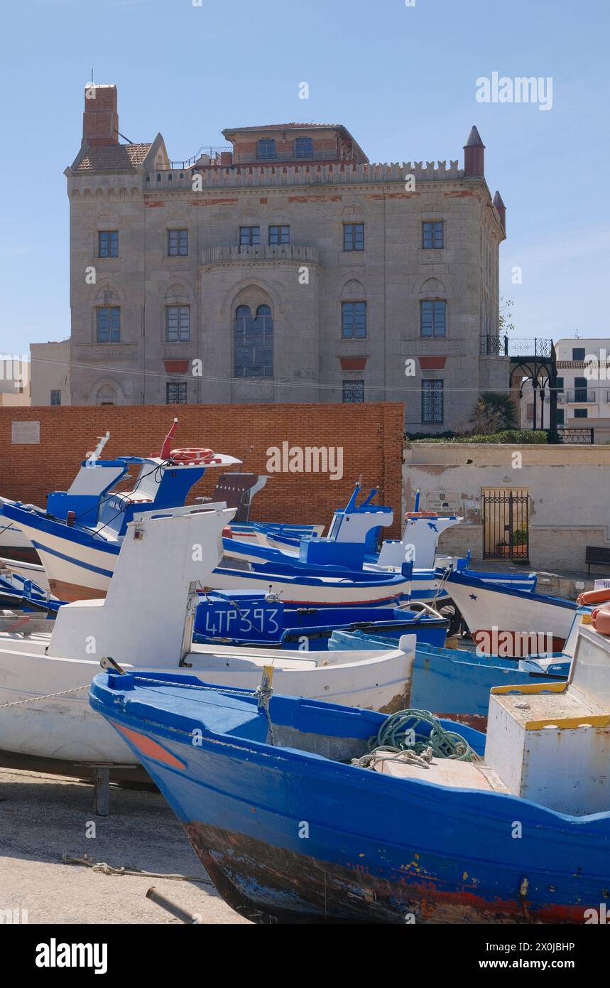 Italien, sizilien, mittelmeer, Ägadische Inseln, Insel Favignana); Boote an Land im Hafen und die Fassade des Florio Palace im Hintergrund Stockfoto
