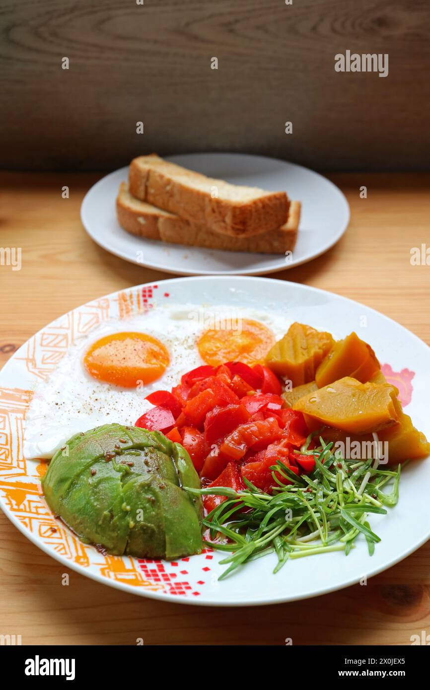 Gesundes Frühstücksgericht mit sonniger Seite oben mit Microgrün und Avocadosalat Stockfoto