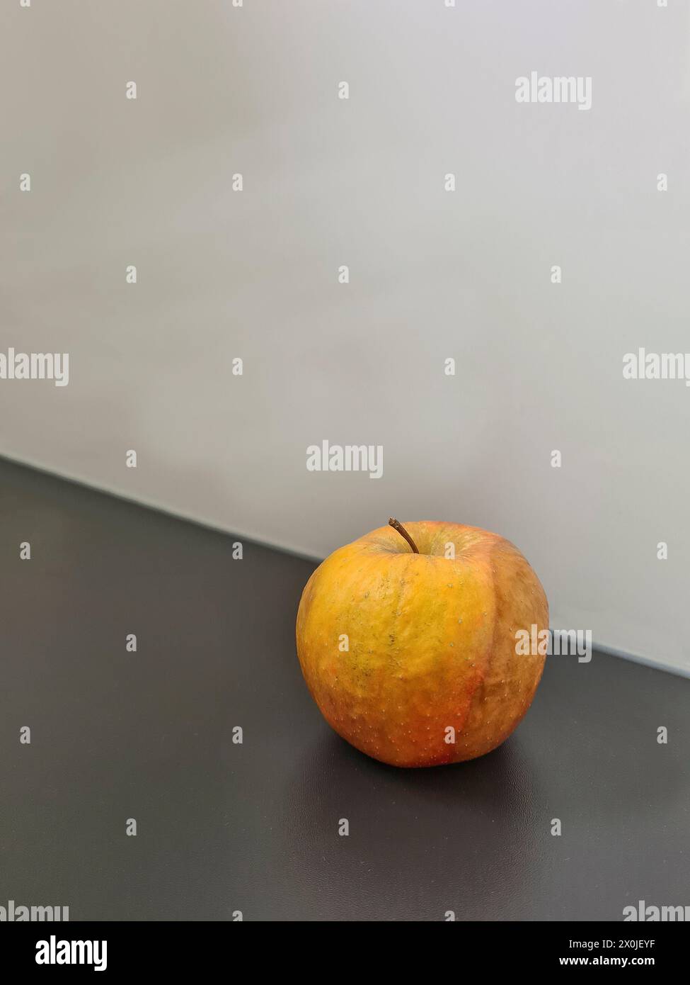 Stillleben mit gelbem Apfel im Verderben, symbolisches Bild von Lebensmittelverschwendung Stockfoto