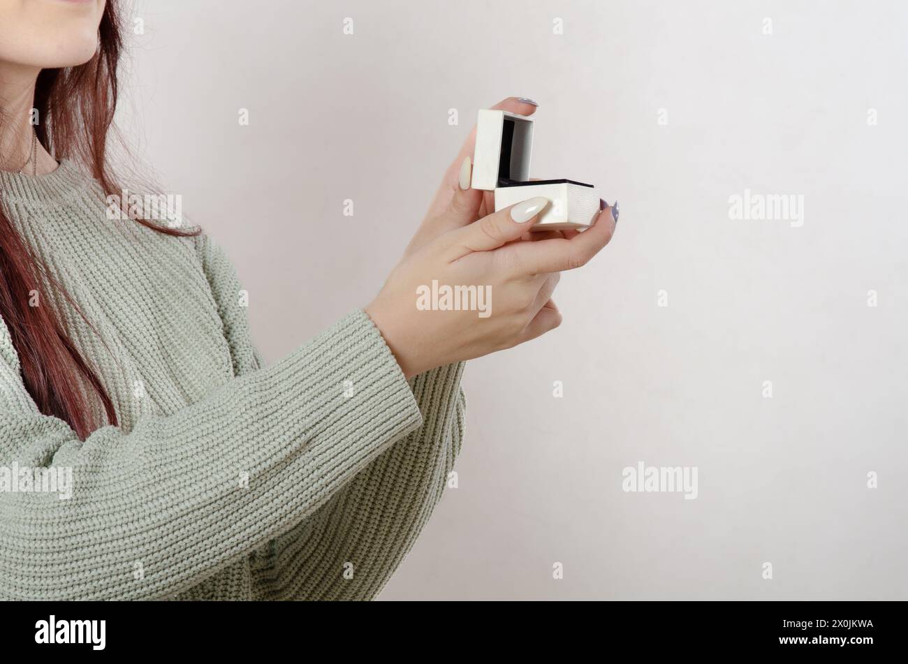 Frau, die einem Freund die Ehe vorschlägt, mit einem Ringkasten in den Händen Stockfoto
