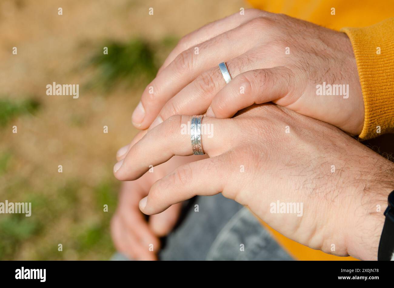 Zwei homosexuelle Männer, die mit Verlobungsringen die Hand schütteln. Homosexualitätsbegriff, Homosexualehen und LGBTI-Konzept Stockfoto
