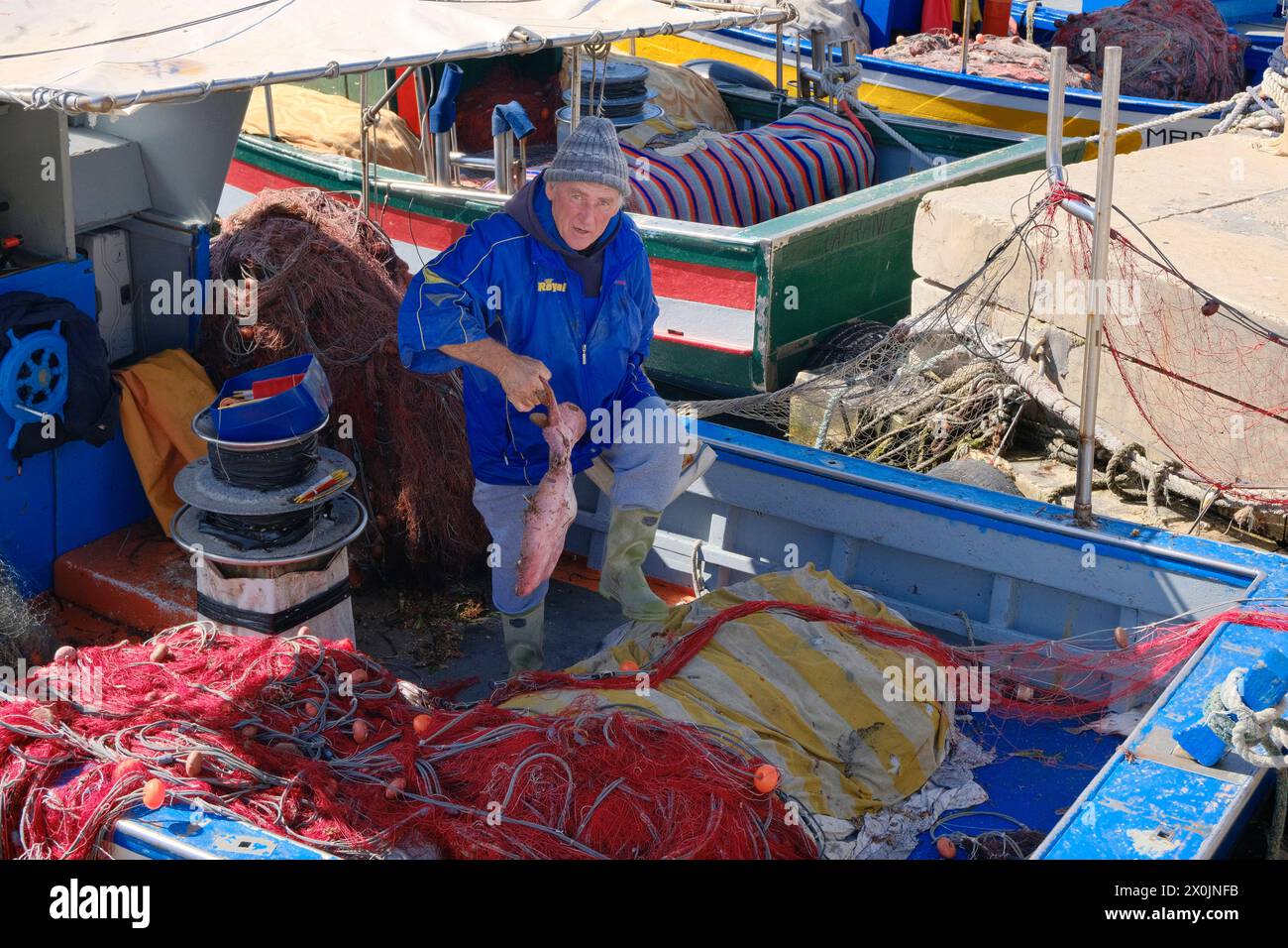 Italien, sizilien, mittelmeer, Ägadische Inseln, Insel Favignana; 21. März 2024, Fischer mit einem großen Seeteufel auf seinem Holzboot - EDITORIAL Stockfoto
