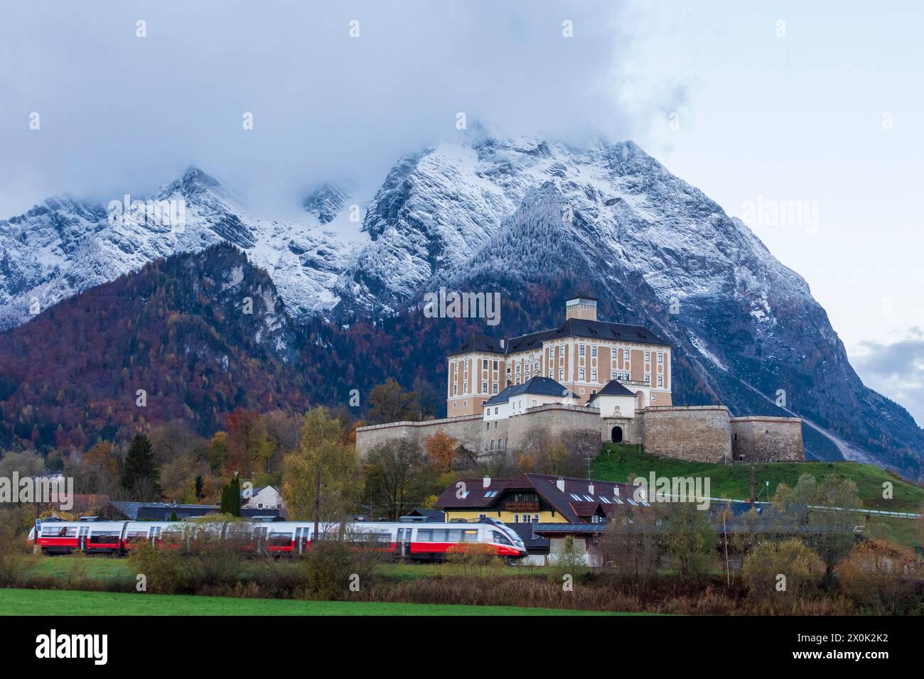 Stainach-Pürgg, Schloss Trautenfels, schneebedeckter Berg Grimming, Regionalbahn der ÖBB in Schladming-Dachstein, Steiermark, Österreich Stockfoto