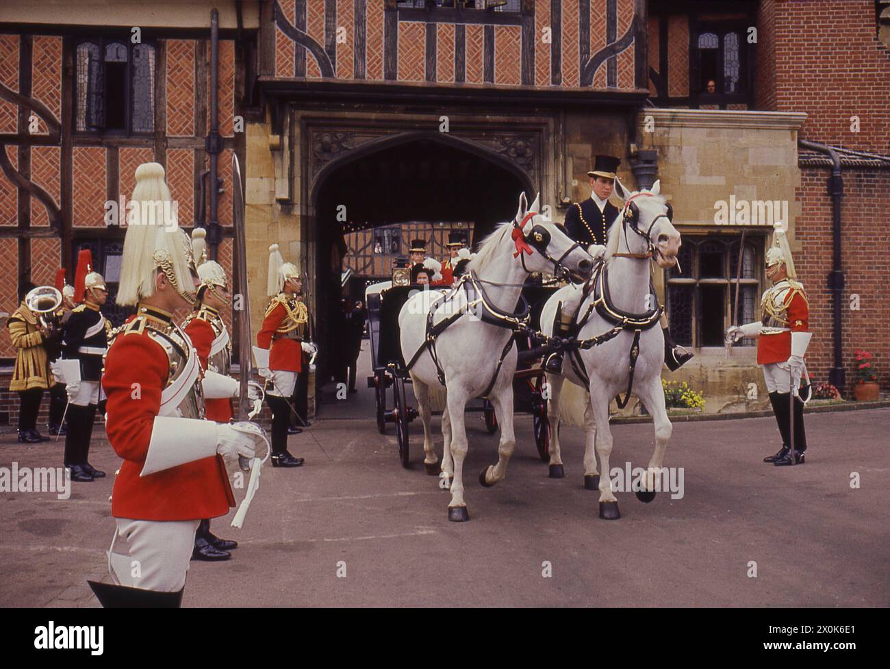 1960er Jahre, historisch, Orden der Garderobe, die britische Königin Elizabeth II. Verließ Windsor Castle in einer Pferdekutsche vor einem stehenden Publikum der Queens Guard, Windsor, Berkshire, England, Großbritannien. Stockfoto
