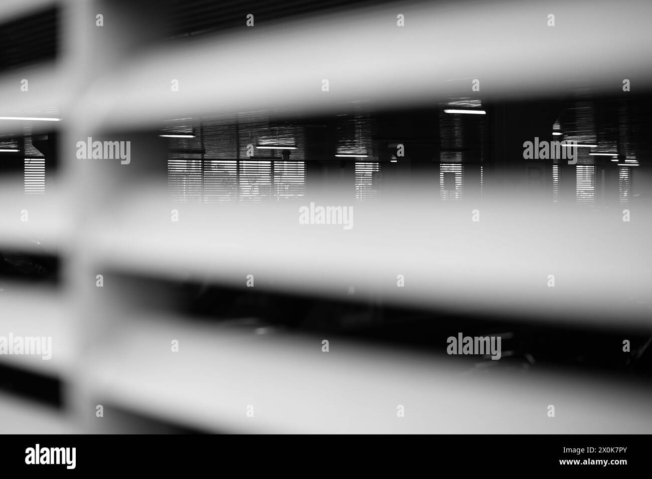 Matel Barrieren, Parkzaun, im Hintergrund verschwommene Lichter im Gebäude. Moderne Zaunstrukturen. Stockfoto
