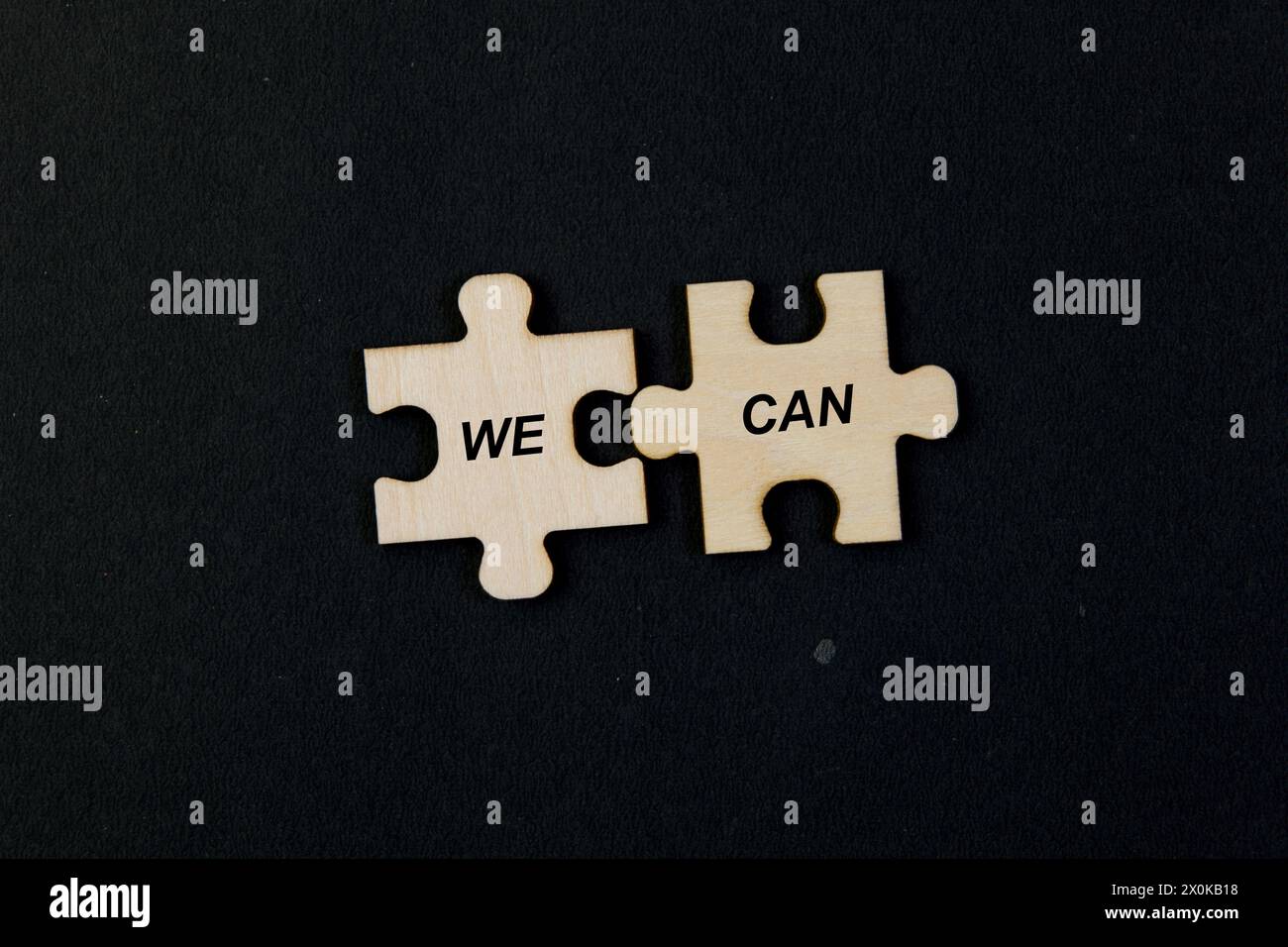 Verschiedene Puzzleteile verzahnen sich, um die inspirierende Botschaft „Wir können“ zu erzeugen. Symbolische Darstellung der Teamarbeit Stockfoto