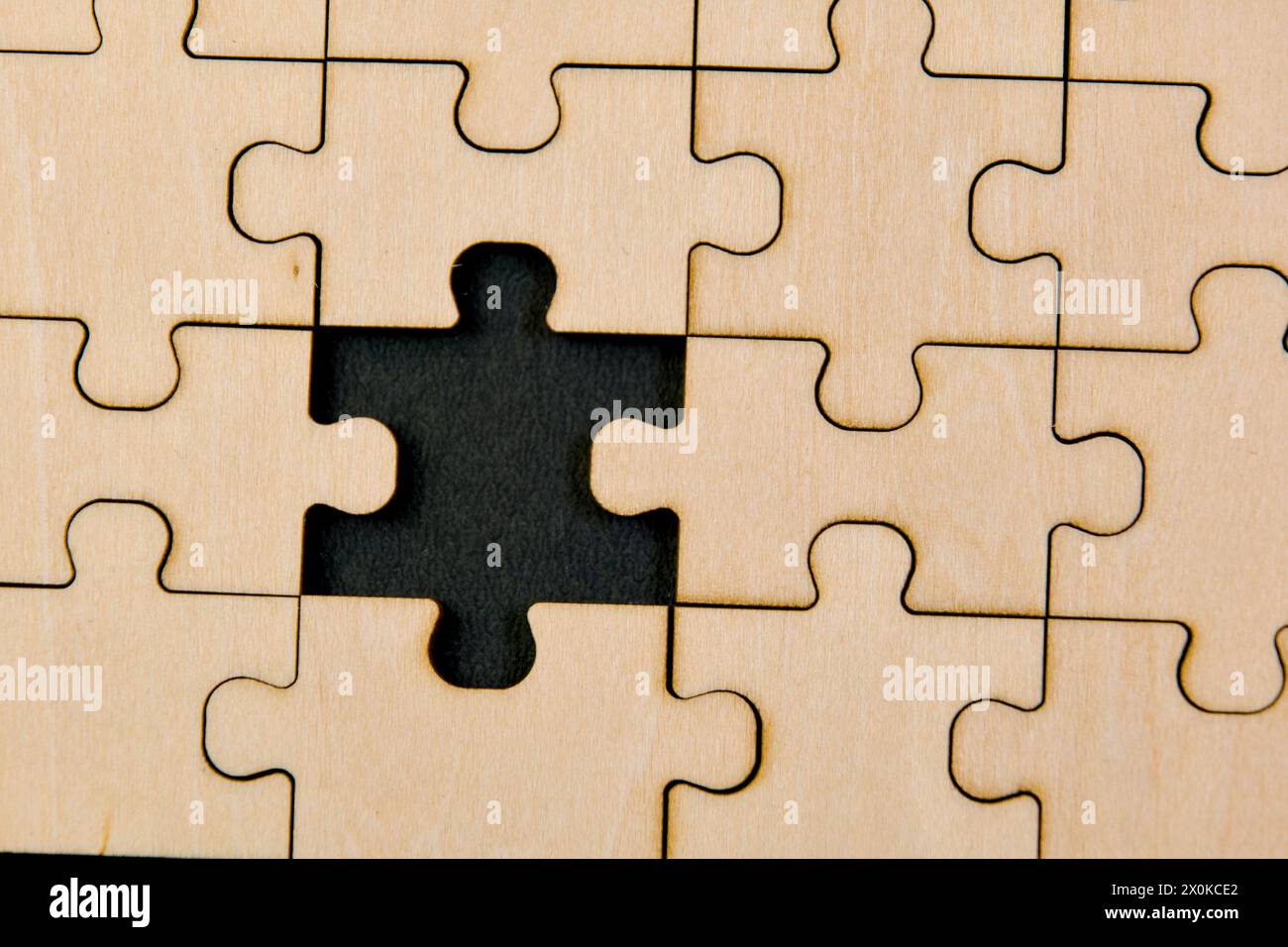 Zusammengesetzte Puzzleteile auf einem Holzbrett symbolisieren die Zusammenarbeit und strategische Planung Stockfoto