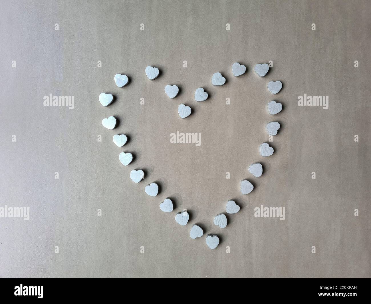 Ein großes silberfarbenes Herz aus vielen kleinen silbernen Herzen als Zeichen der Liebe zum Muttertag Stockfoto