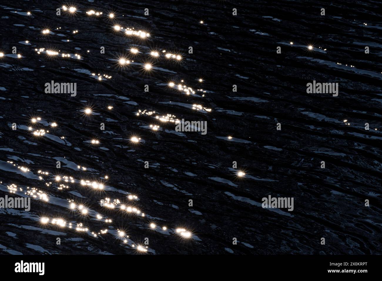 Lichtreflexionen durch Sonnenlicht auf der Oberfläche eines Sees, kleine Wellen und Sterne, Deutschland Stockfoto