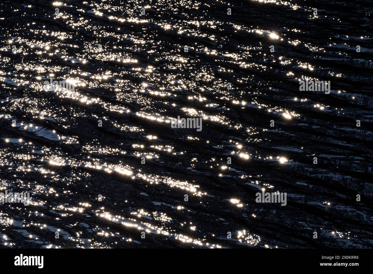 Lichtreflexionen durch Sonnenlicht auf der Oberfläche eines Sees, kleine Wellen und Sterne, Deutschland Stockfoto