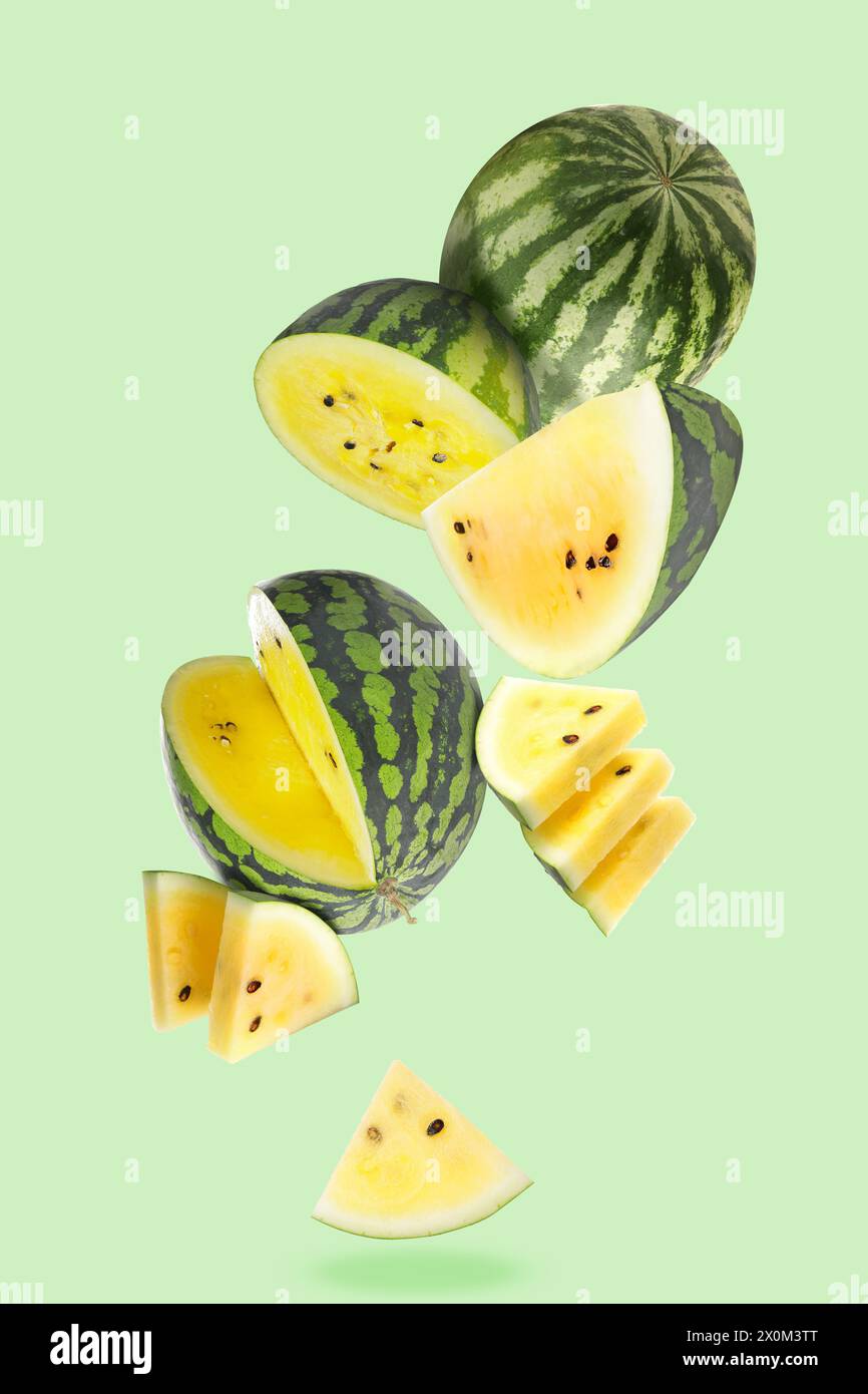 Fliegende gelbe Wassermelonen auf grünem Hintergrund Stockfoto