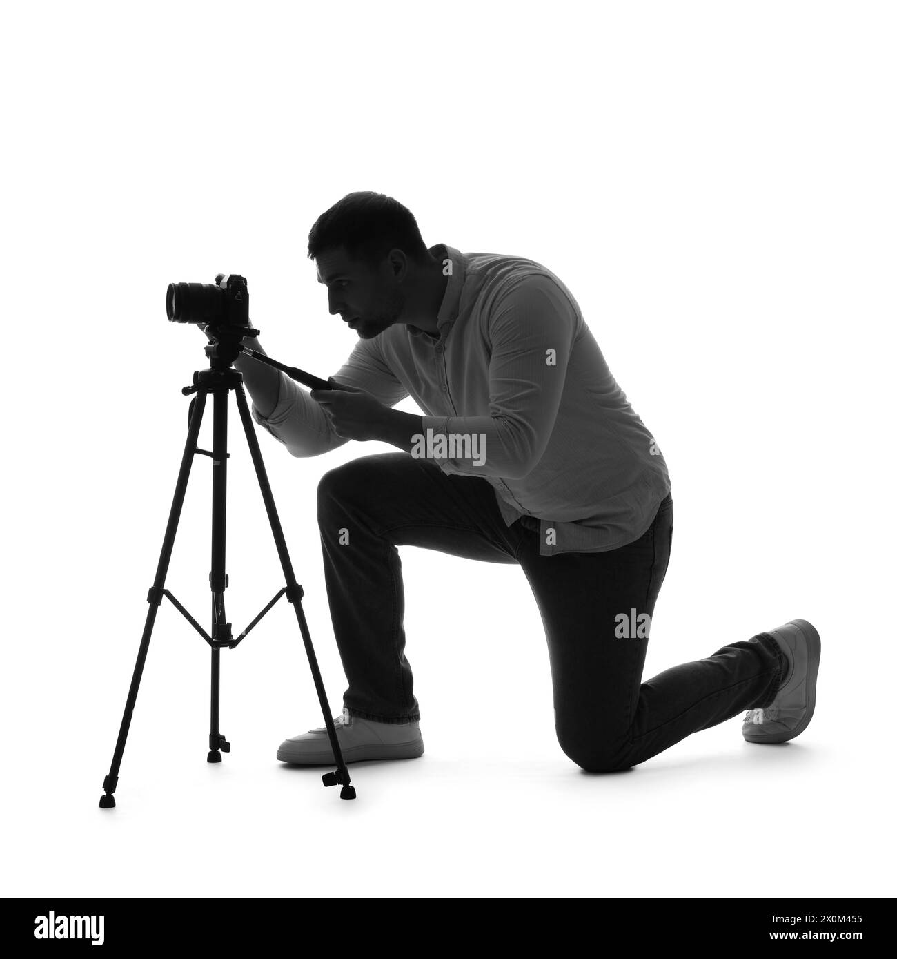 Silhouette eines männlichen Fotografen mit Kamera auf weißem Hintergrund Stockfoto